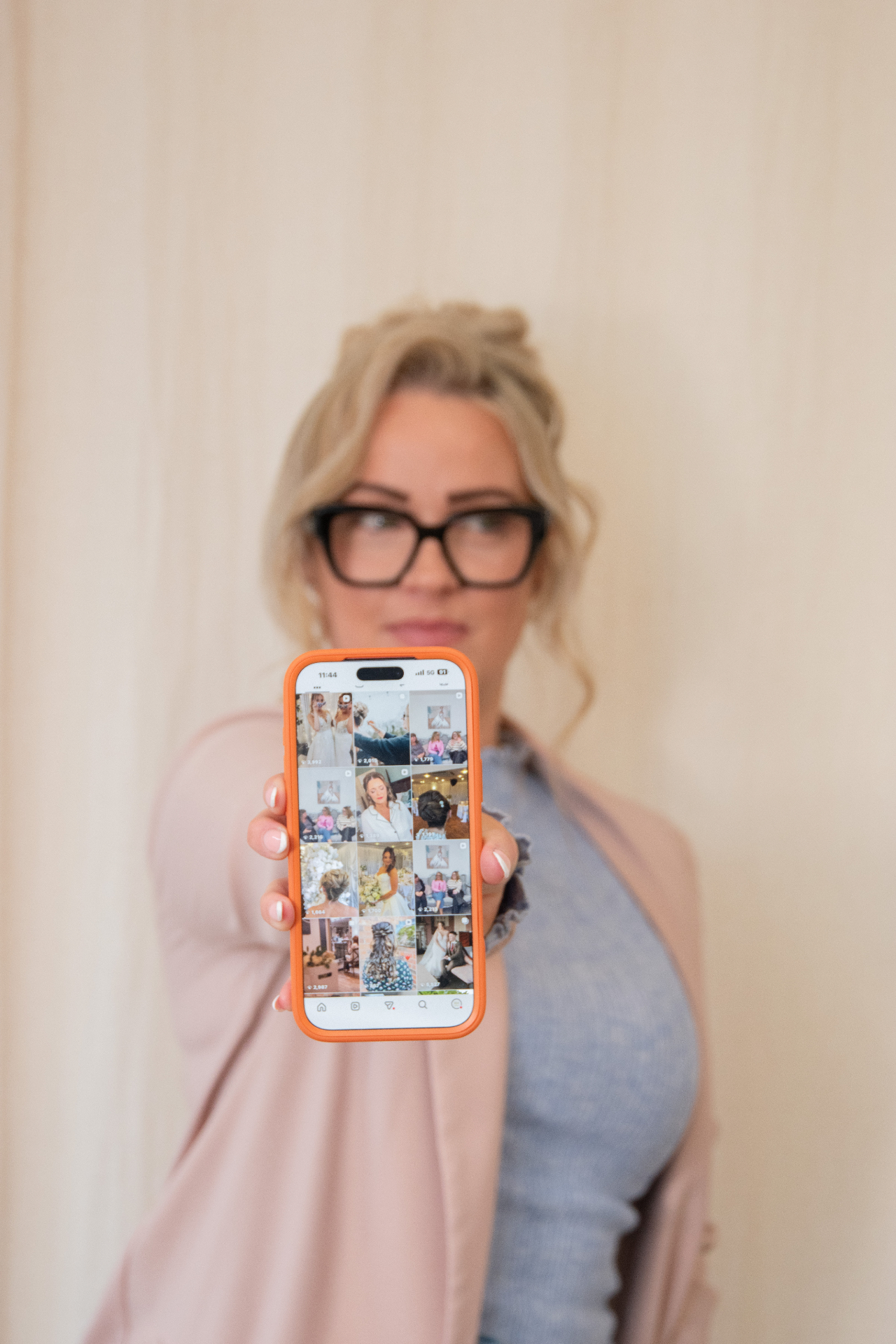 Business owner holding out her phone showing her social feed