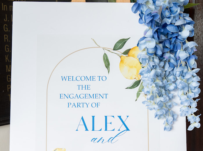 Close detail of an engagement party sign with blue hydrangea