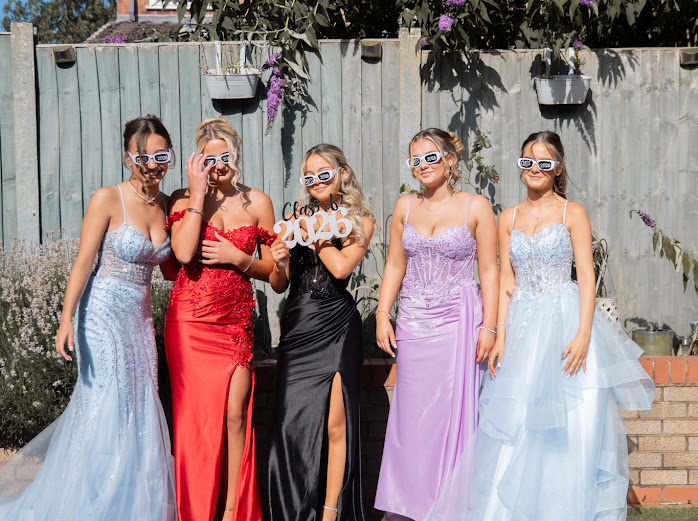 Friends in prom dresses wearing Class of 2026 glasses