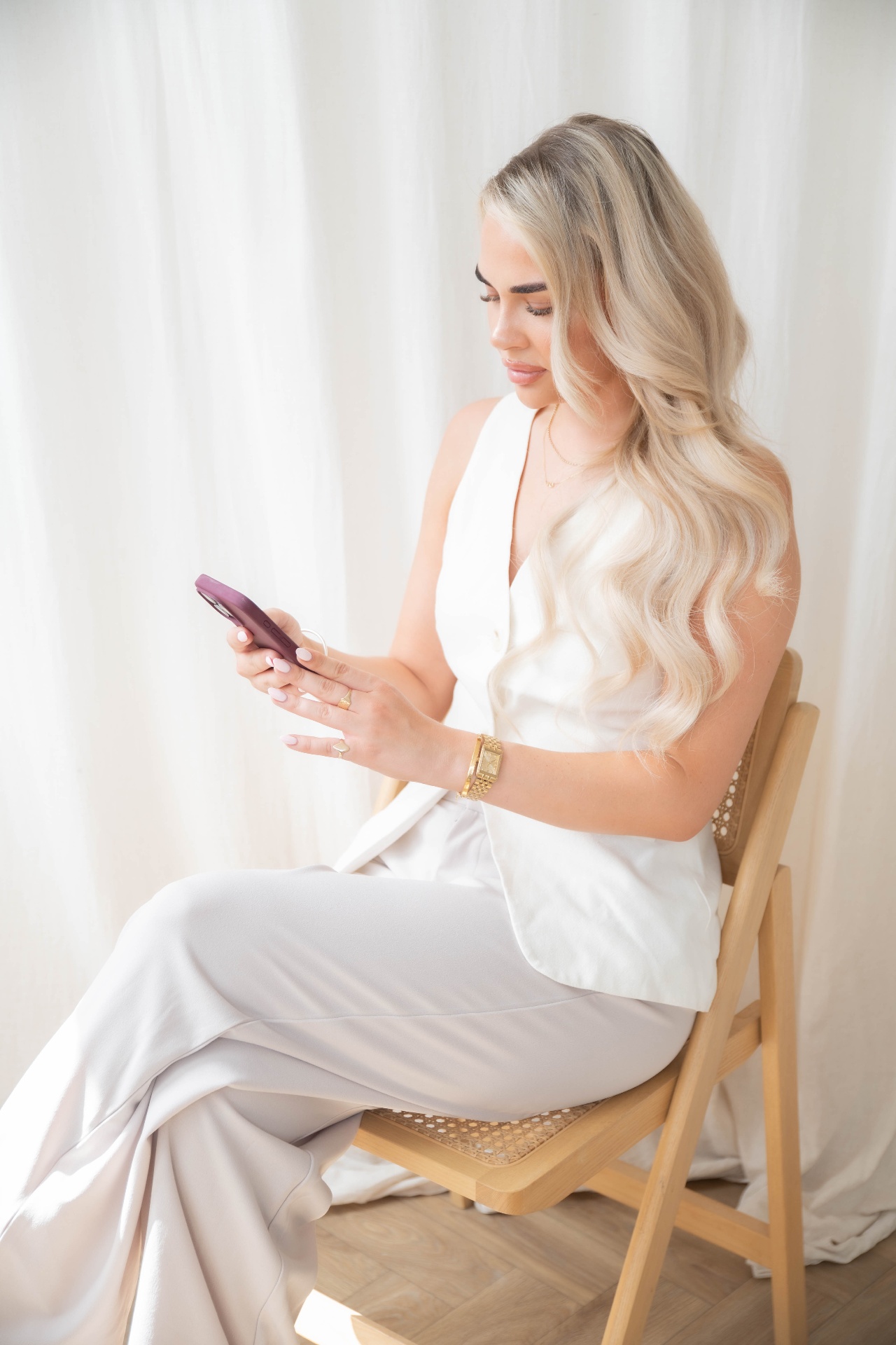 Business owner seated on a cane chair working from her phone