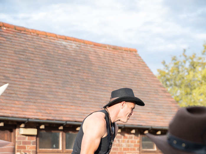 Guest in a cowboy hat riding the bucking bronco at a charity rodeo