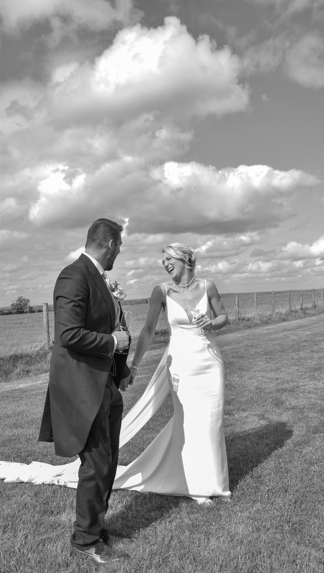 Black and white portrait of a couple laughing with champagne