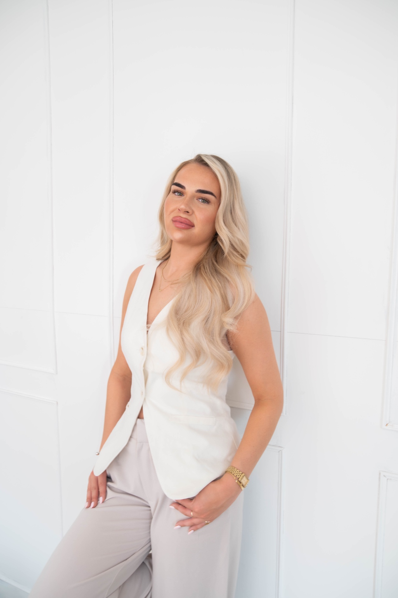 Business owner in a cream waistcoat against a panelled wall